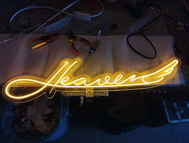Neon illuminated logo on plexiglass background